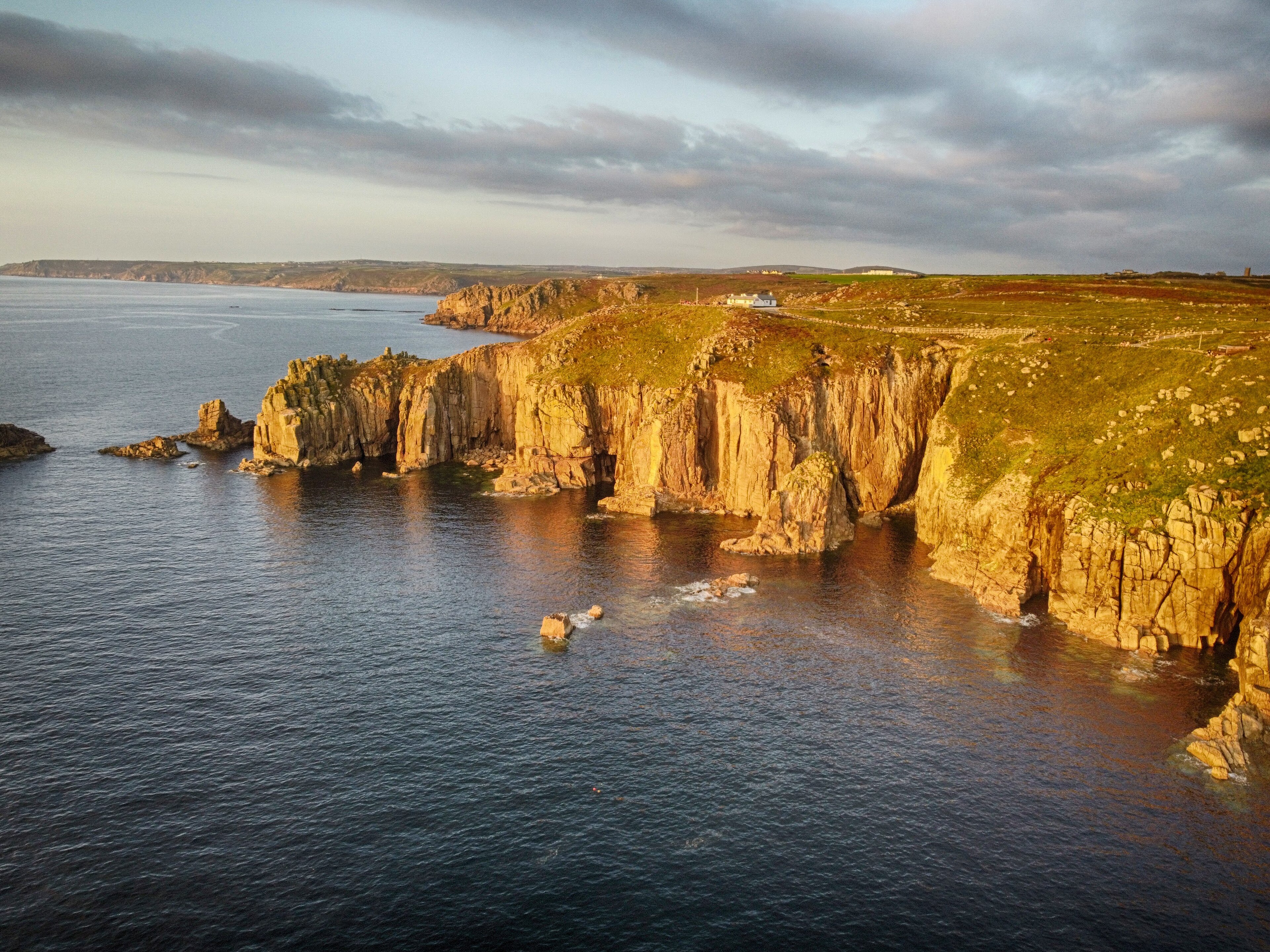 Aerial drone view of the cliffs at Land's End, Cornwall at golden hour